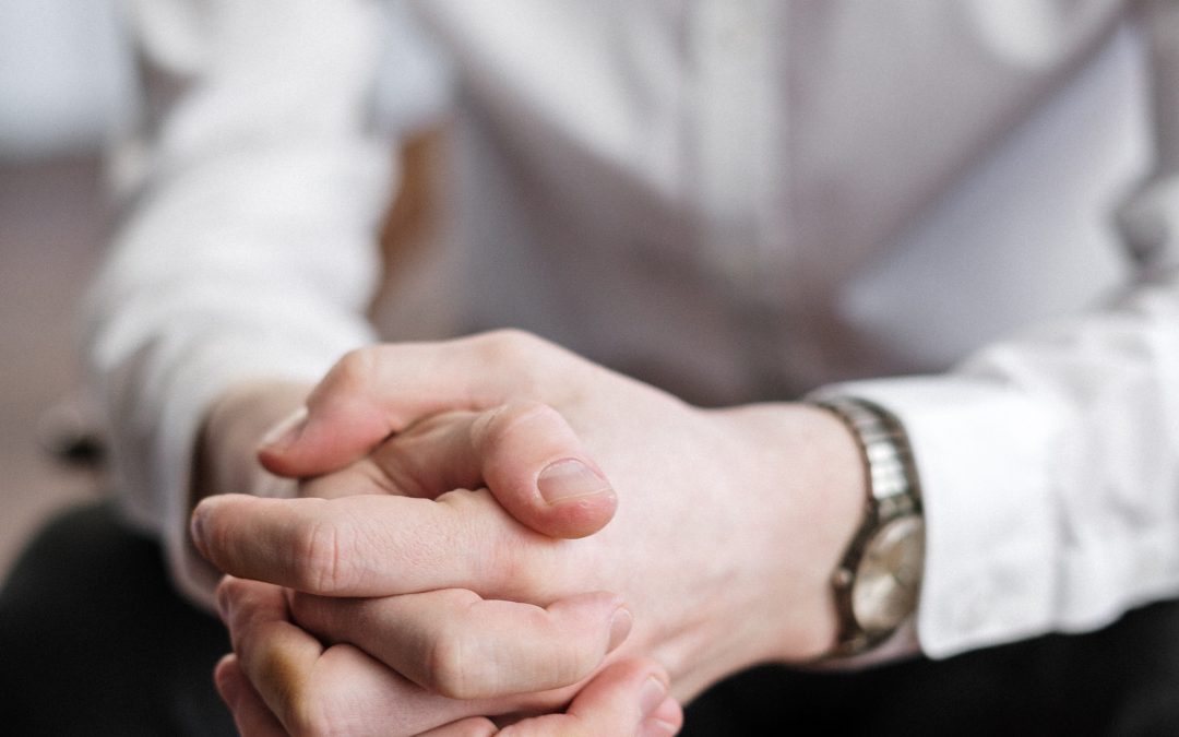 A legal client sits with his hands clasped together, worrying about the outcome of his case